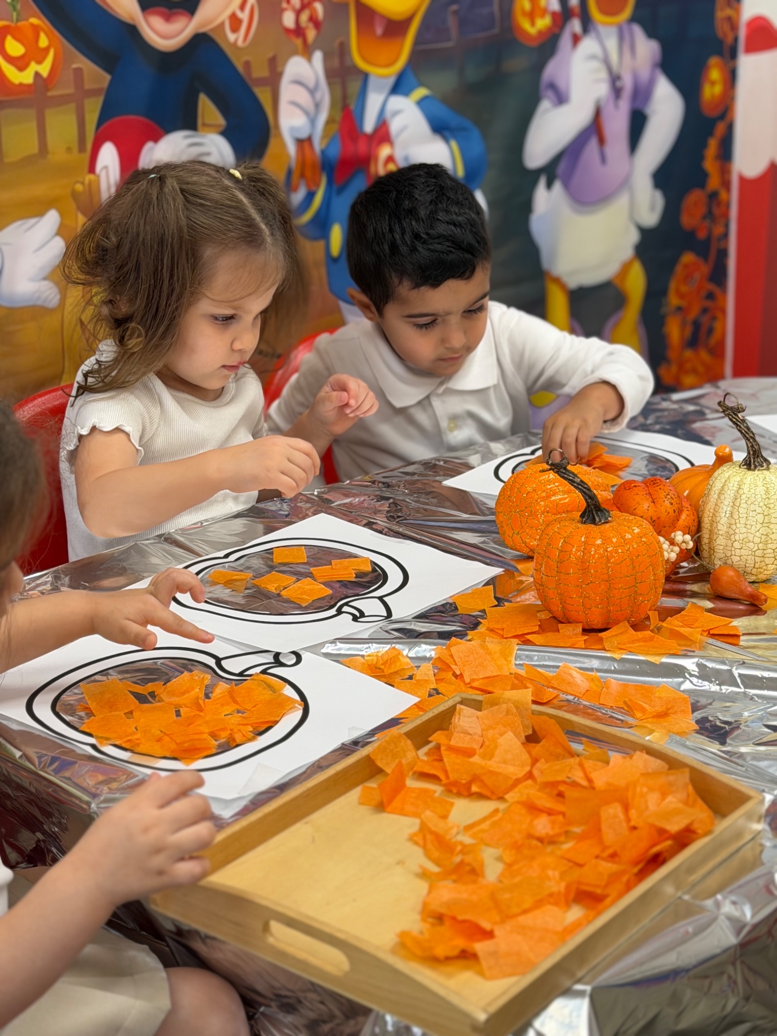Young children creating seasonal artwork together