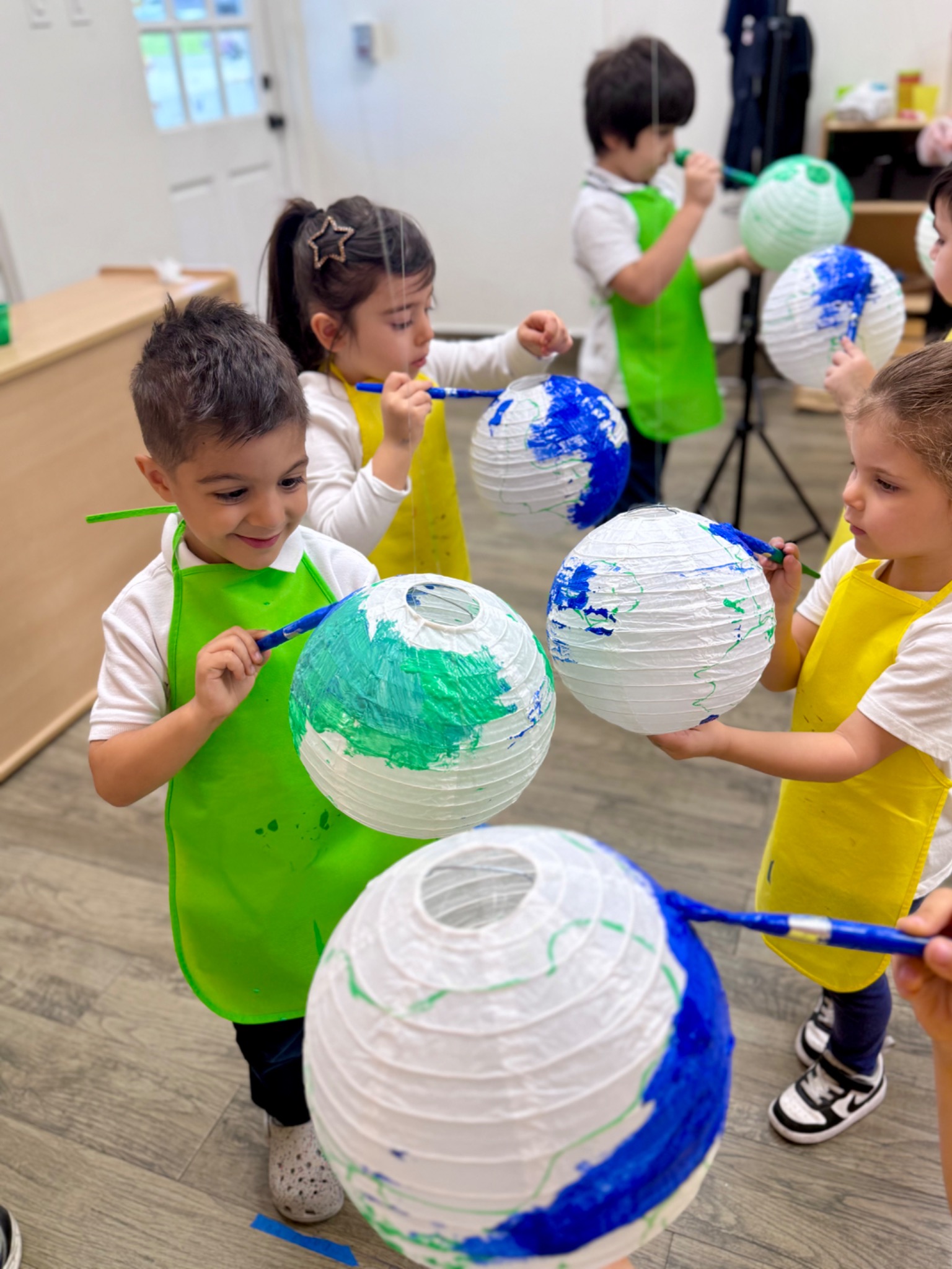 Preschool children working together on a collaborative Earth-themed art project