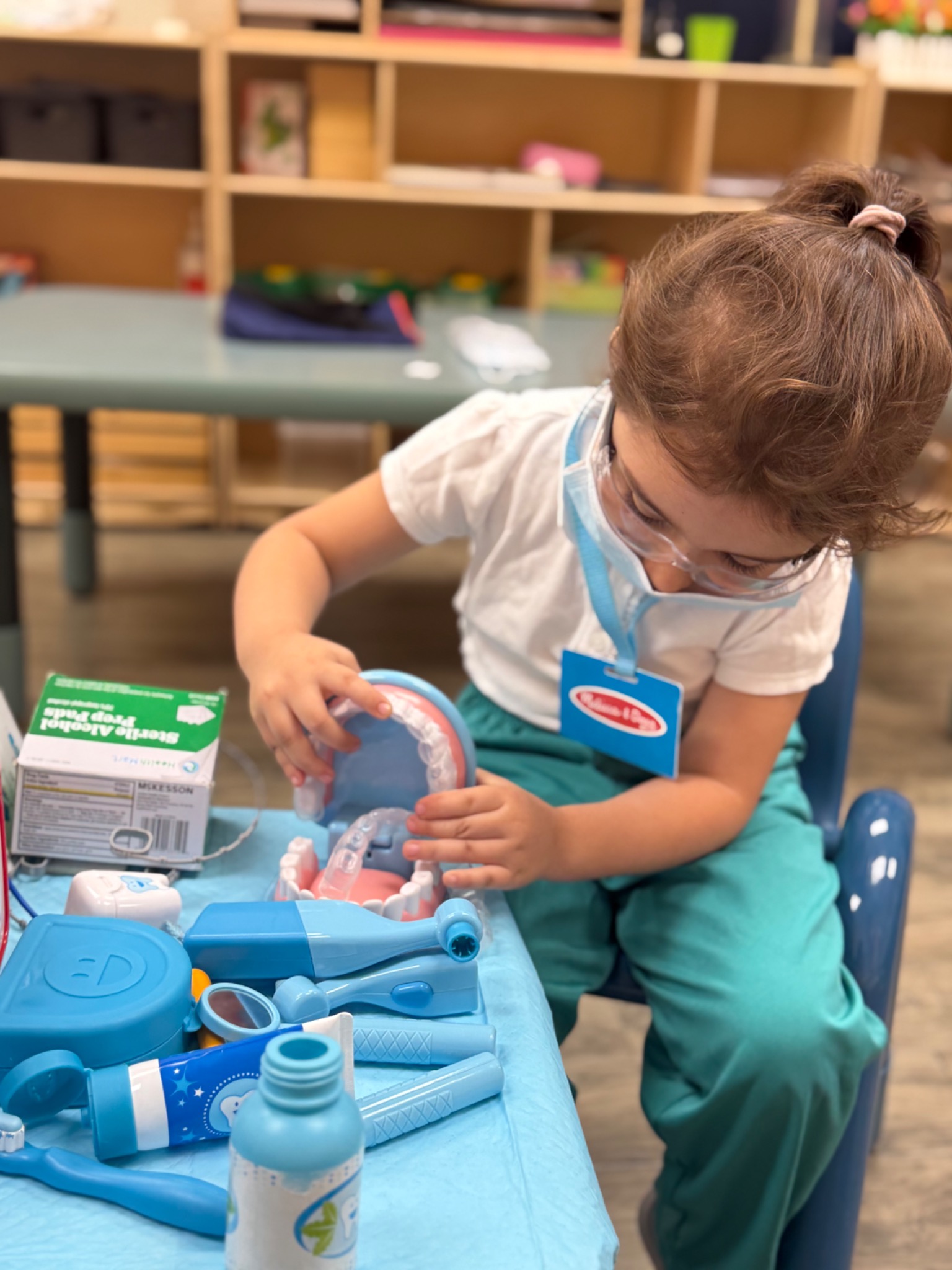 A preschool child practicing pouring and transferring during independent practical-life work
