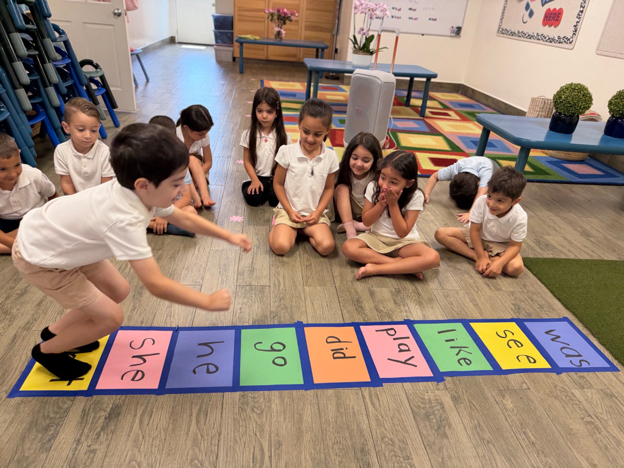 Kindergarten students participating in a group phonics and word-building lesson